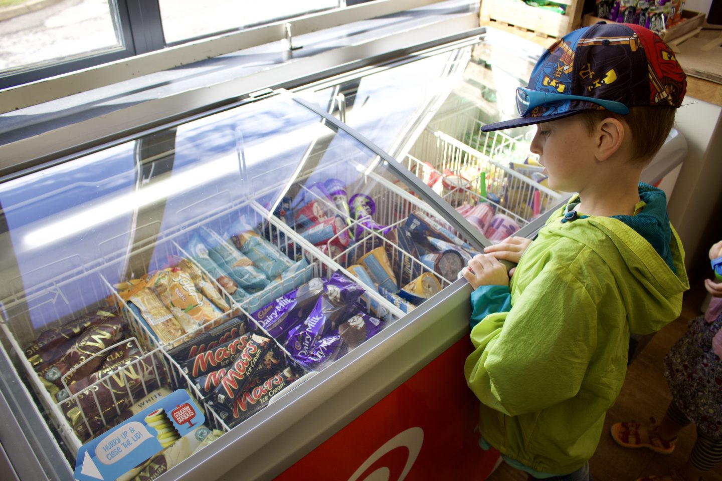 Little boy choosing an ice cream from a freezer