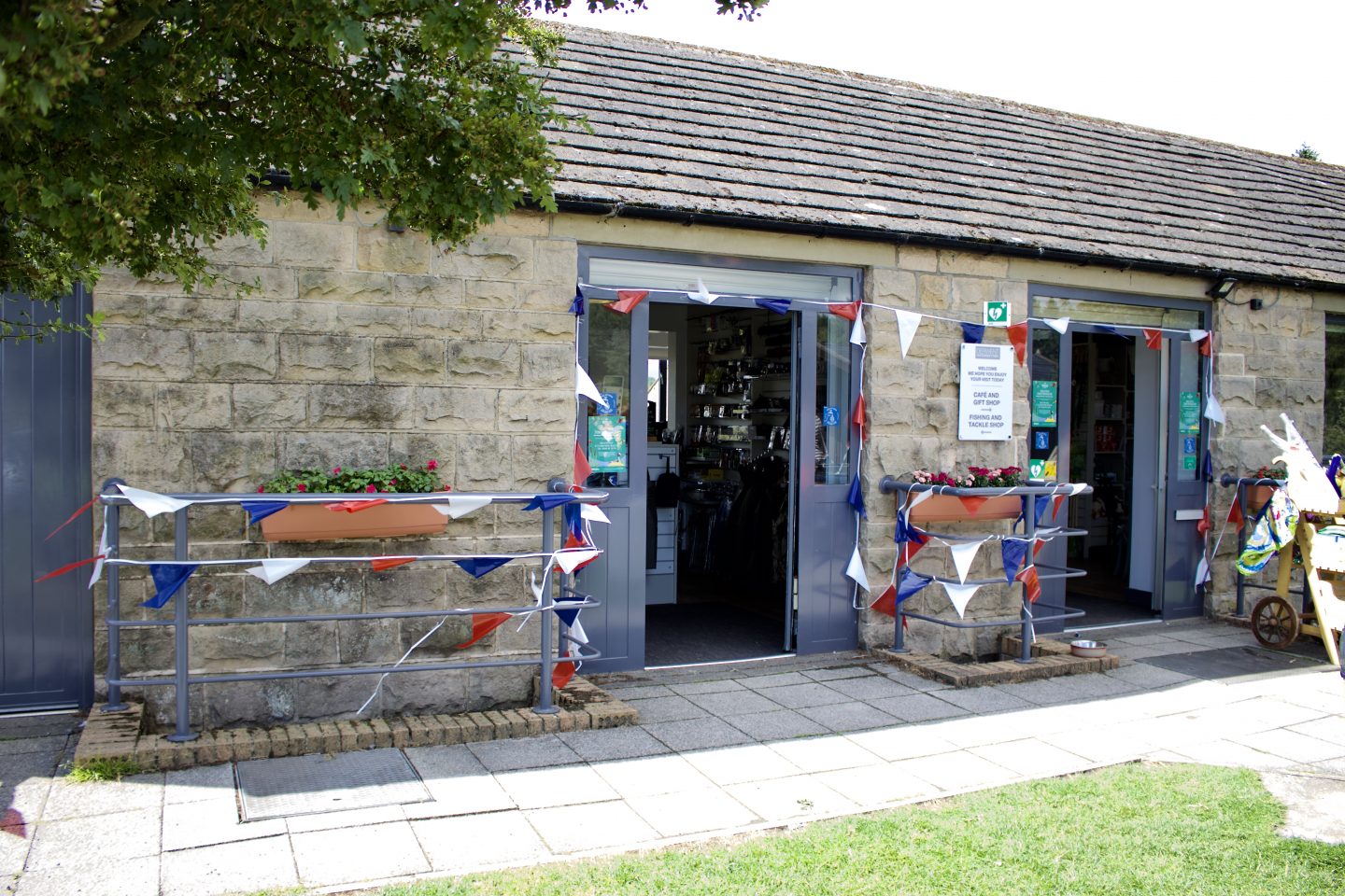 A photo of the outside of the cafe - a stone building with red, white and blue bunting