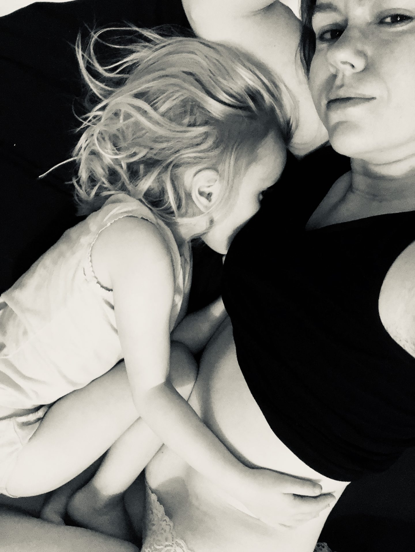 A 4 year old cuddling her mother whilst breastfeeding